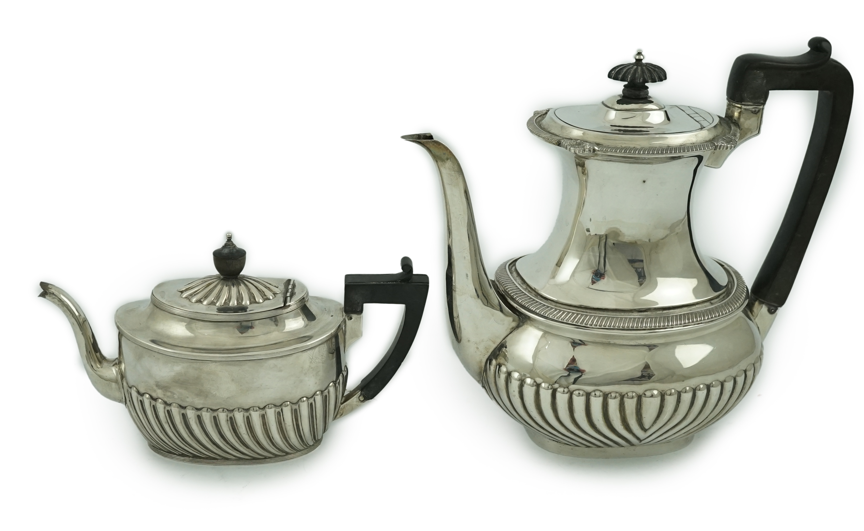 An Edwardian demi-fluted silver oval coffee pot by Mappin & Webb, Sheffield, 1902 and a similar tea pot by Henry Harrison, Sheffield, 1884